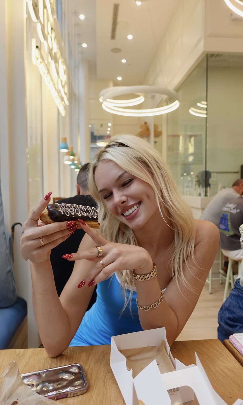 Madeline smiling with a dessert at a cafe