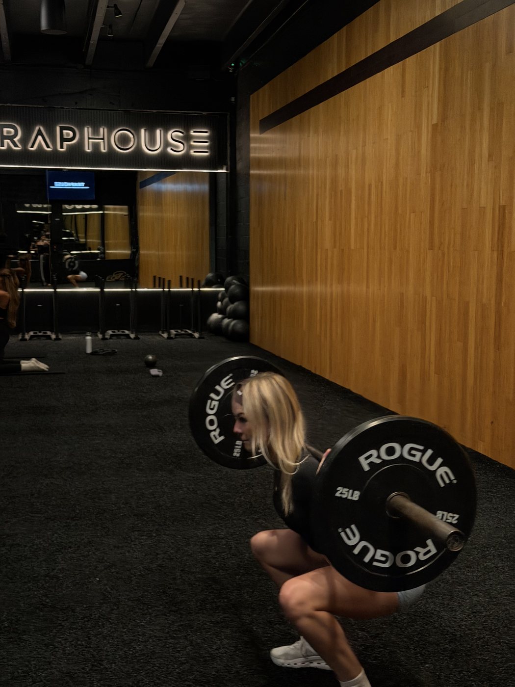 Madeline crouched by a loaded barbell