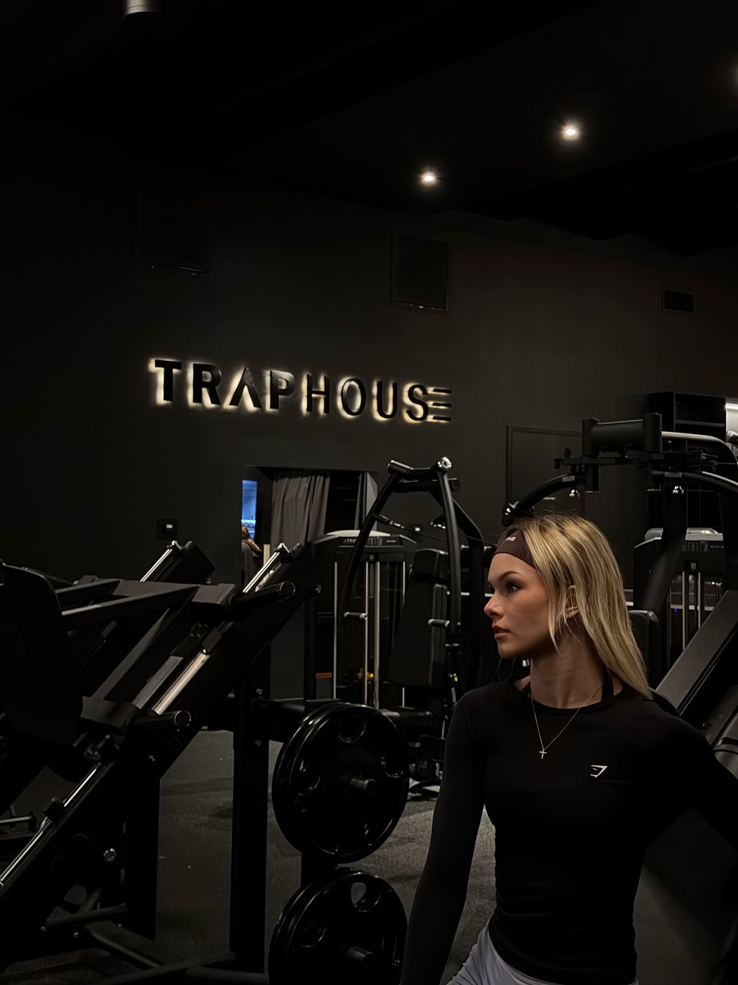 Madeline standing among the machines in a dark gym