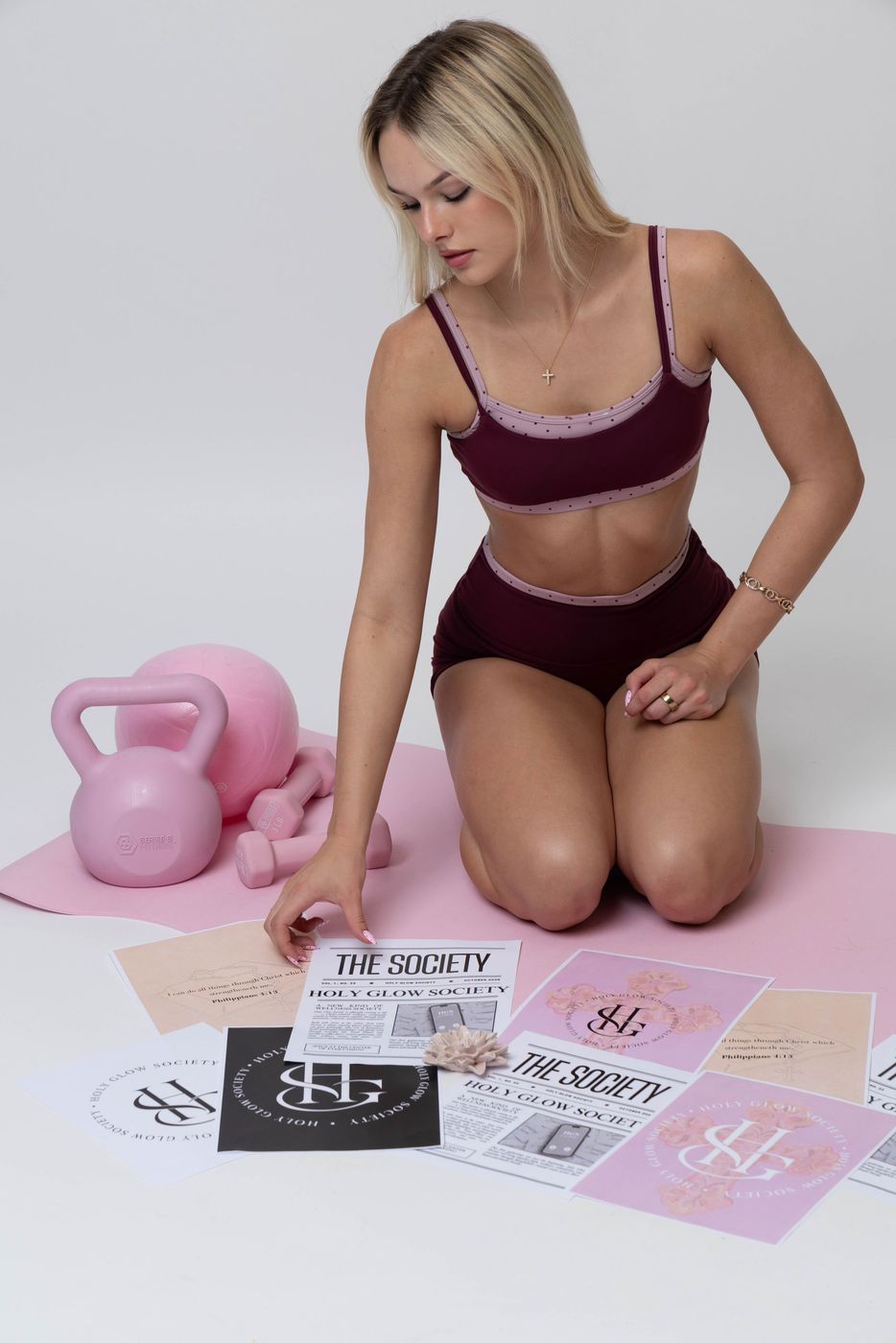 Madeline kneeling with The Society flyers